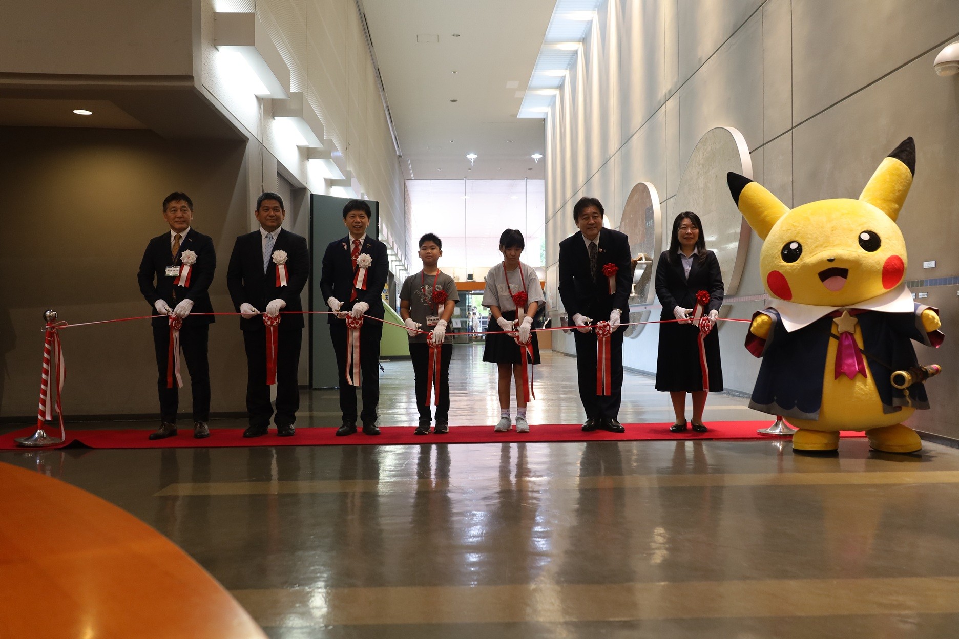 Upacara pemotongan pita. Pikachu Starry Sky juga hadir.
